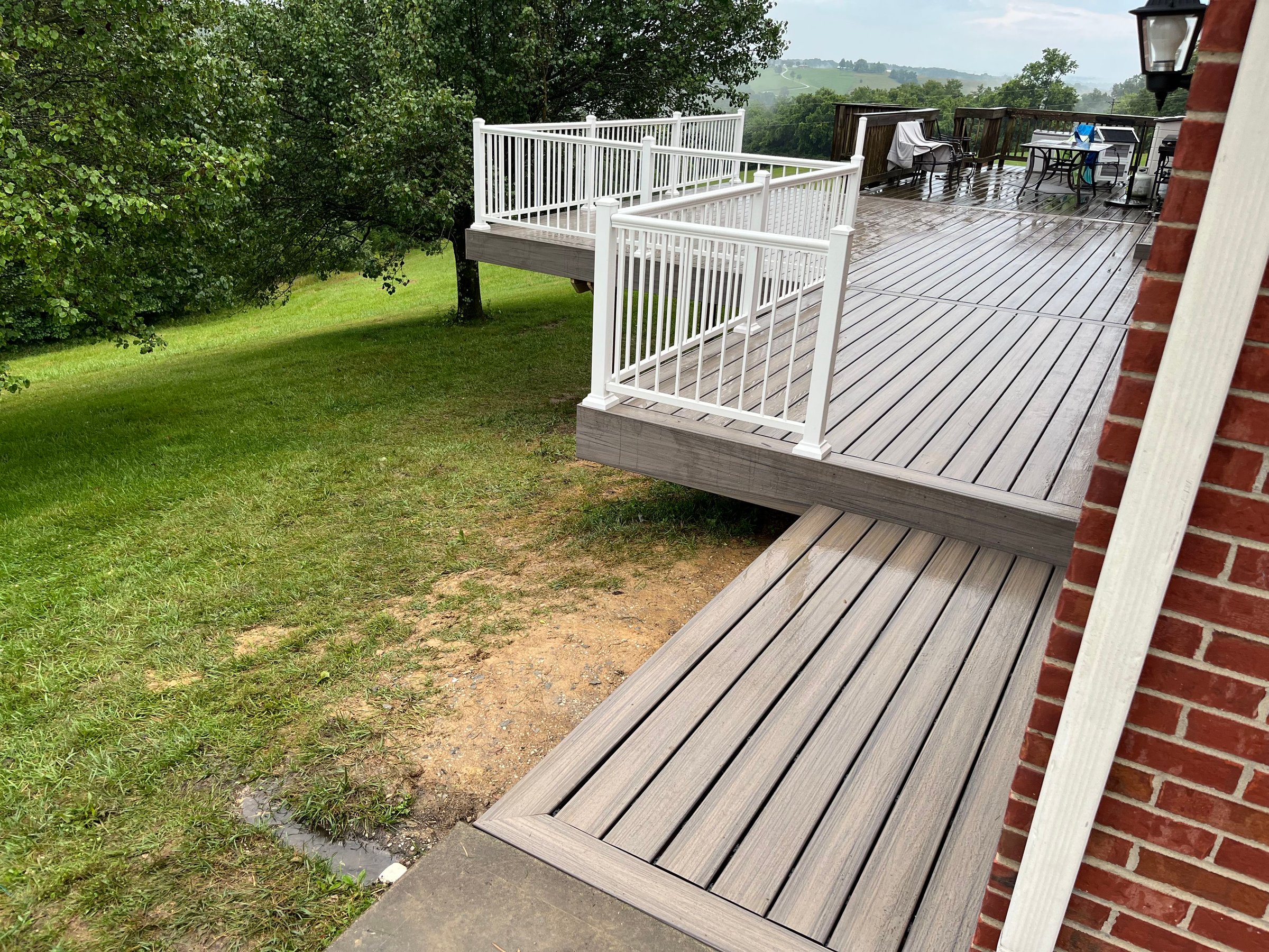 Finished multi-level composite deck with white railing overlooking a green Northern Kentucky hillside